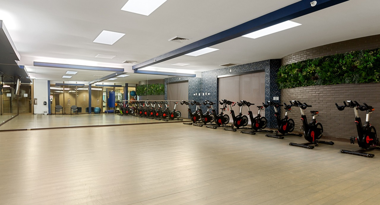 Dedicated spin and yoga studio at Arrive Streeterville with stationary bikes, mirrors, and ample floor space
