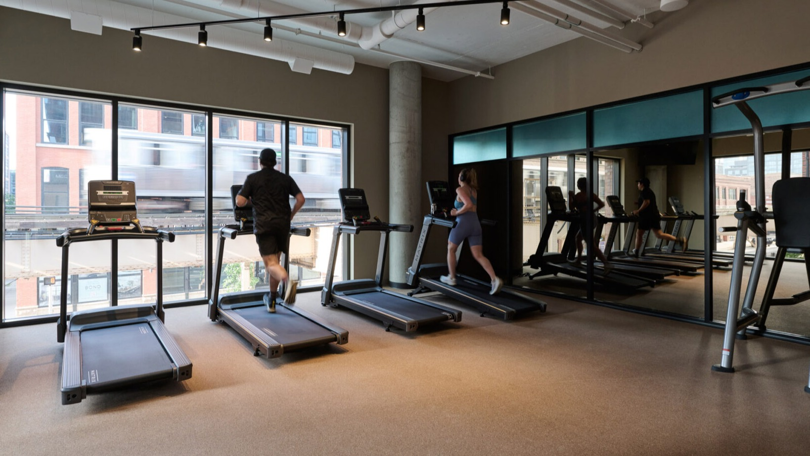 Modern fitness center at Arthur on Aberdeen in Chicago with treadmills and ample space for cardio workouts