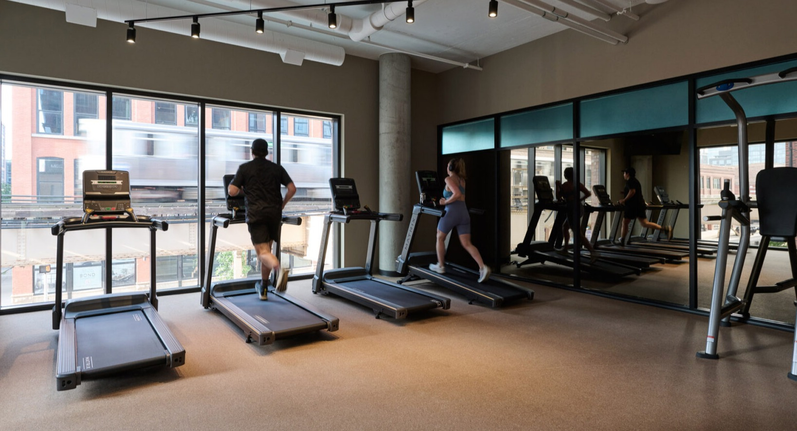 Modern fitness center at Arthur on Aberdeen in Chicago with treadmills and ample space for cardio workouts
