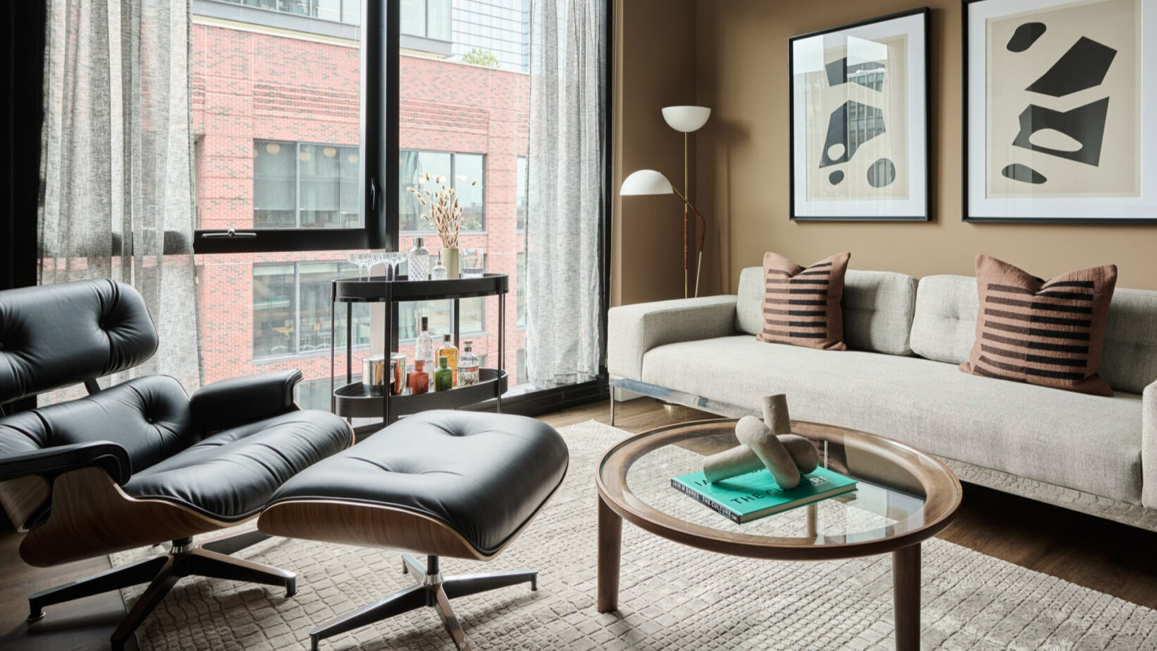 Stylish living room in an Arthur on Aberdeen apartment in Chicago, with comfortable seating and large windows