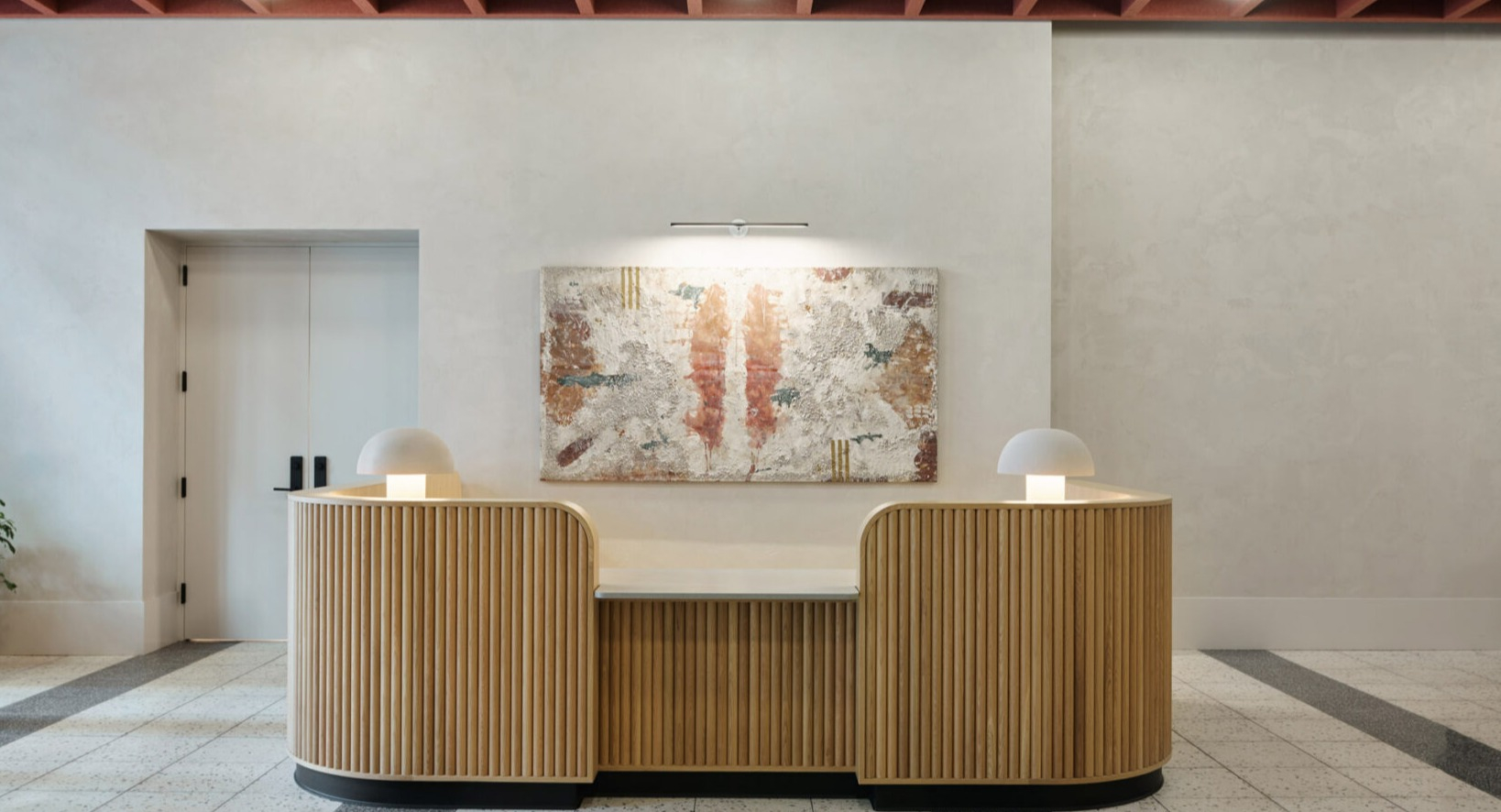 Elegant lobby reception desk at Arthur on Aberdeen in Chicago, featuring unique lighting and modern architectural details