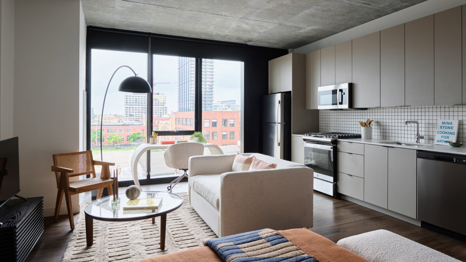 Open-concept apartment living space at Arthur on Aberdeen in Chicago, combining kitchen and living areas with city views