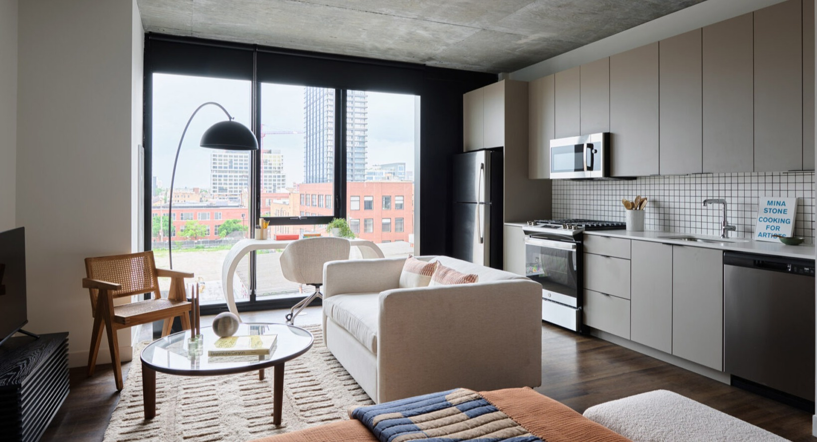 Open-concept apartment living space at Arthur on Aberdeen in Chicago, combining kitchen and living areas with city views