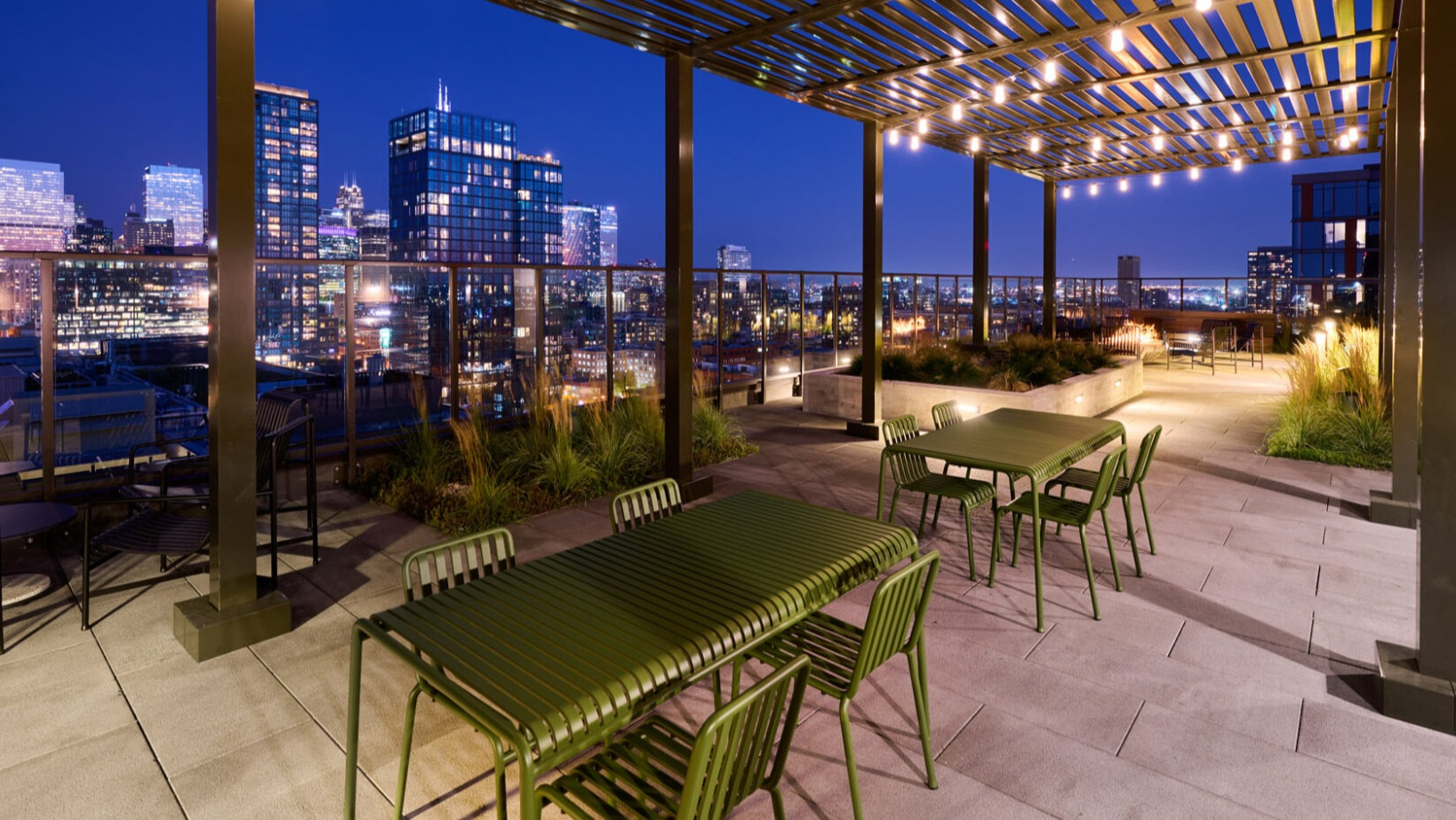 Enchanting rooftop dining and lounge area at Arthur on Aberdeen in Chicago, illuminated at night with city lights