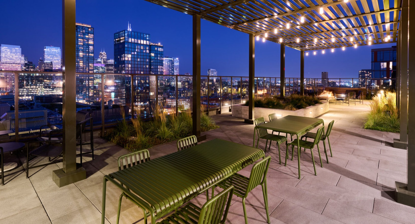 Enchanting rooftop dining and lounge area at Arthur on Aberdeen in Chicago, illuminated at night with city lights