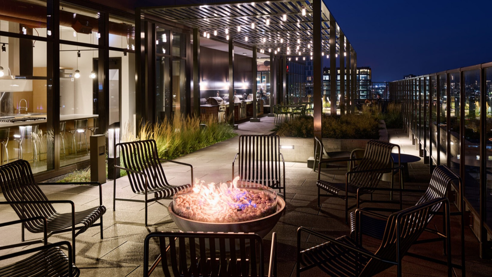 Cozy rooftop fire pit area at Arthur on Aberdeen in Chicago at night, perfect for relaxing with city views