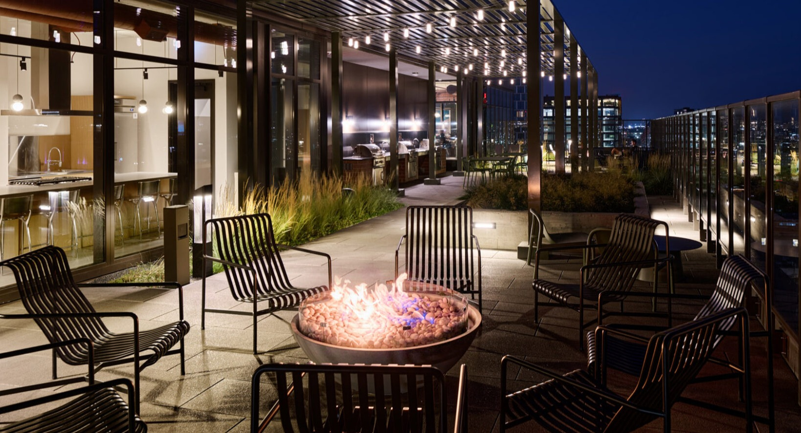 Cozy rooftop fire pit area at Arthur on Aberdeen in Chicago at night, perfect for relaxing with city views