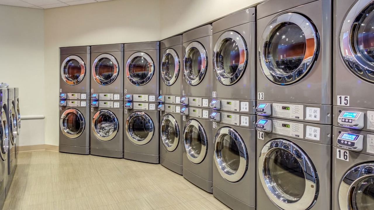 Convenient on-site laundry room at Asbury Plaza in Chicago, featuring numerous modern washing machines
