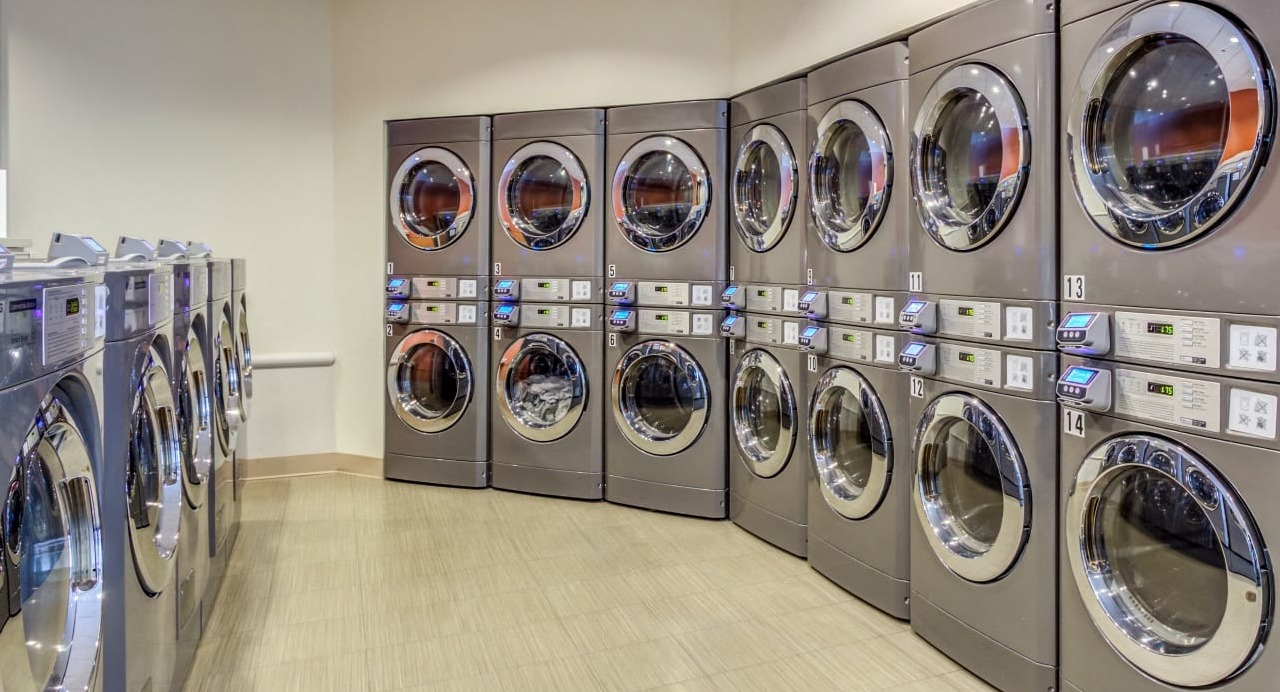 Convenient on-site laundry room at Asbury Plaza in Chicago, featuring numerous modern washing machines