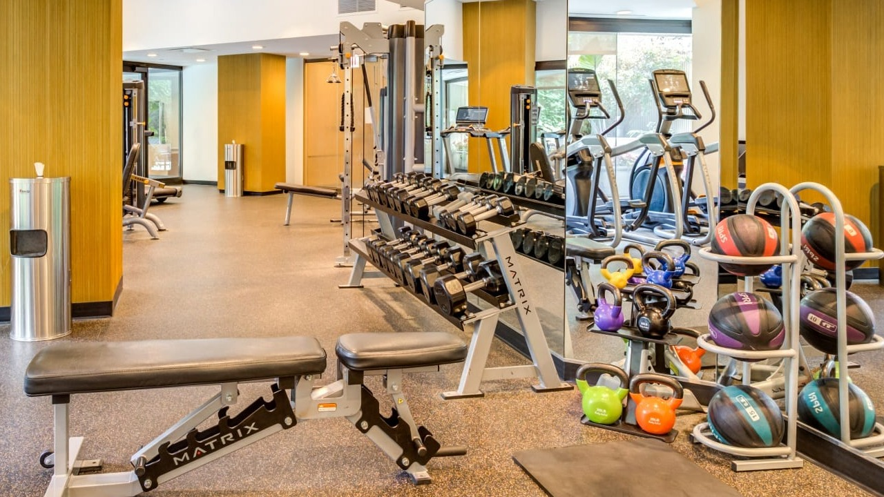 Well-equipped fitness center at Asbury Plaza in Chicago, offering free weights, benches, and exercise balls