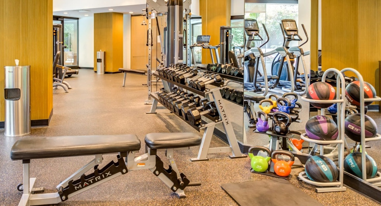 Well-equipped fitness center at Asbury Plaza in Chicago, offering free weights, benches, and exercise balls