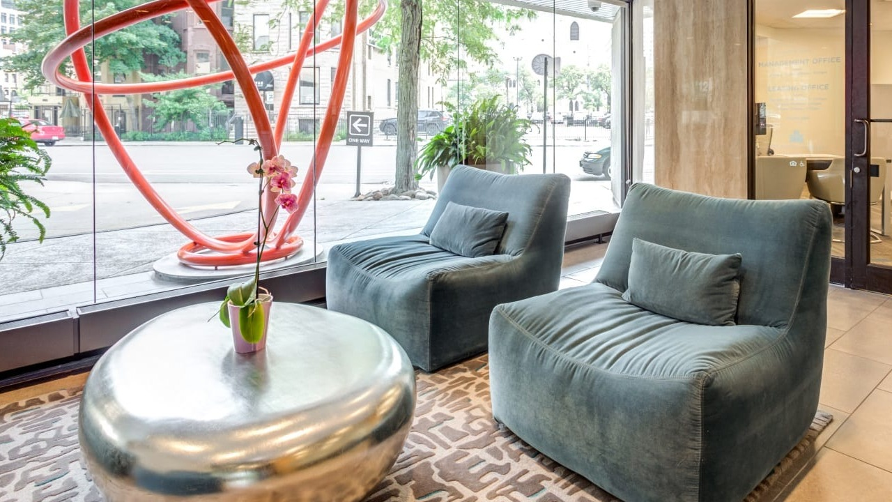Welcoming resident lounge at Asbury Plaza in Chicago, featuring comfortable seating and large windows