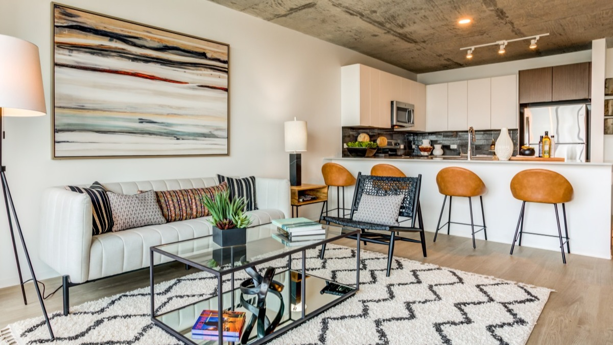 Open-concept living room and kitchen at Aspire Residences in Chicago with modern furniture and bar seating