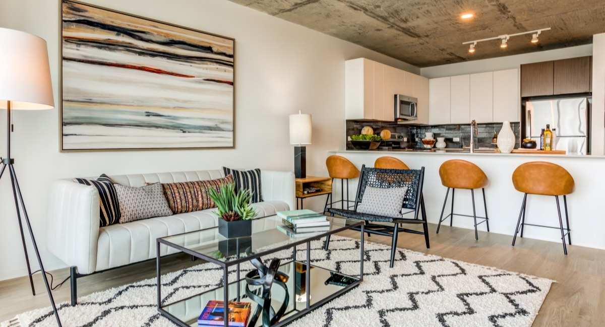 Open-concept living room and kitchen at Aspire Residences in Chicago with modern furniture and bar seating