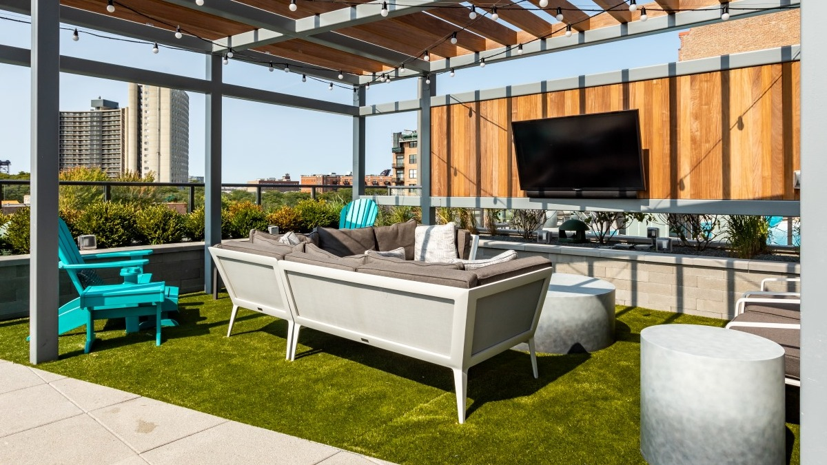Beautiful outdoor lounge terrace at Aspire Residences in Chicago with comfortable seating and a TV
