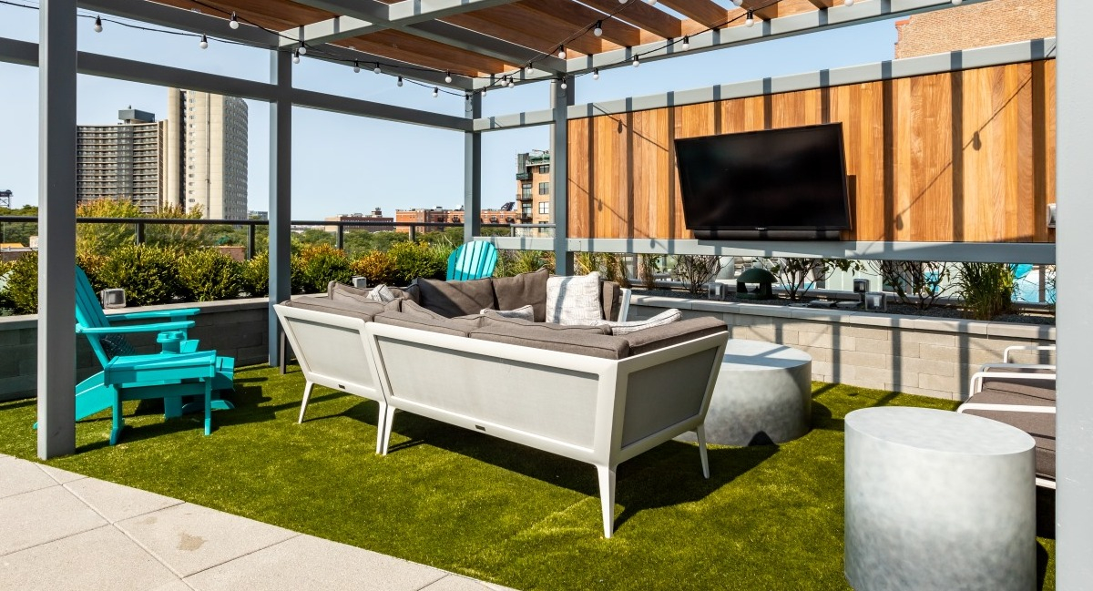 Beautiful outdoor lounge terrace at Aspire Residences in Chicago with comfortable seating and a TV