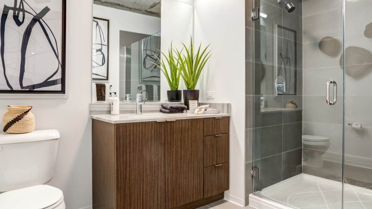 Stylish bathroom at Aspire Residences in Chicago, featuring a modern vanity, glass shower, and elegant decor