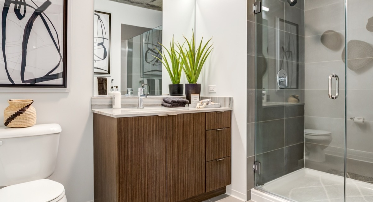 Stylish bathroom at Aspire Residences in Chicago, featuring a modern vanity, glass shower, and elegant decor