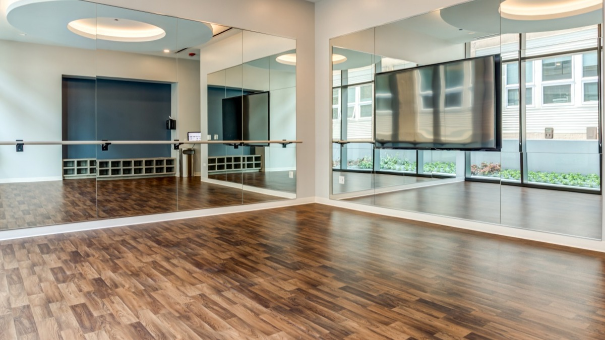 Spacious yoga and fitness studio at Aspire Residences in Chicago with mirrors, ballet barre, and hardwood floors