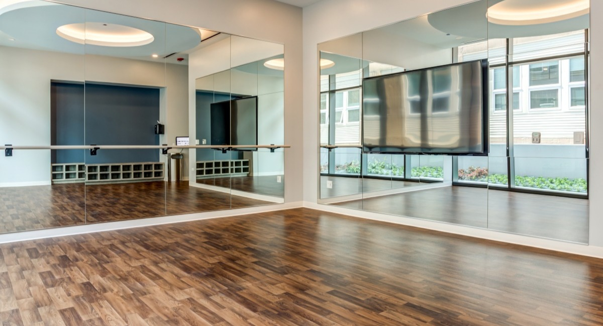 Spacious yoga and fitness studio at Aspire Residences in Chicago with mirrors, ballet barre, and hardwood floors