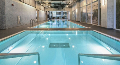 Inviting indoor swimming pool with clear blue water and easy entry steps at Aston Chicago Apartments in Chicago