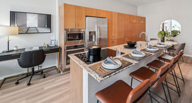 Fully equipped kitchen with a large island, dining setup, and a convenient desk area at Aston Chicago Apartments
