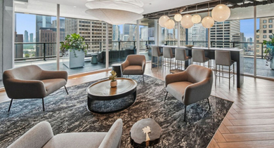 Elegant lounge area with various seating options, modern lighting, and stunning city views at Aston Chicago Apartments