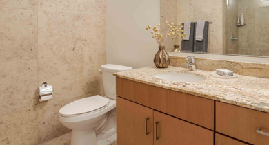 Elegant bathroom with a large vanity, contemporary fixtures, and stylish tiled walls at Aston Chicago Apartments