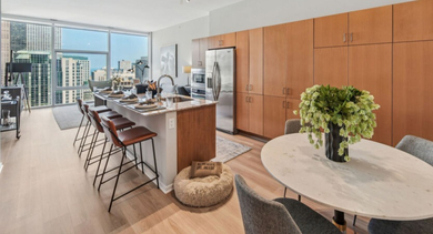 Contemporary kitchen with abundant cabinet space, a large island, and a chic dining table at Aston Chicago Apartments