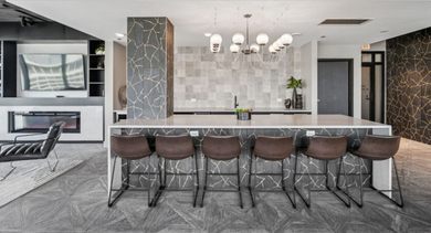 Sophisticated resident lounge with a large island, bar seating, and a contemporary fireplace at Aston Chicago Apartments