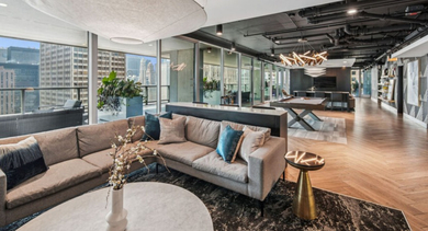 Expansive resident lounge with comfortable seating, a pool table in the background, and city views at Aston Chicago Apartments
