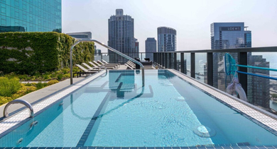 Stunning rooftop outdoor pool with lounge chairs and breathtaking city skyline views at Aston Chicago Apartments