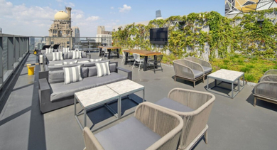 Expansive rooftop patio with comfortable outdoor seating, lush greenery, and stunning city views at Aston Chicago Apartments