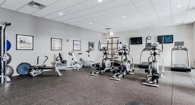 Spacious resident fitness center with various cardio machines and weight training equipment at Astoria Tower Chicago apartments