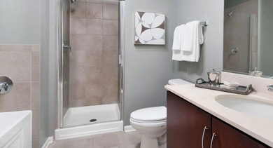 Spacious bathroom featuring a shower, bathtub, large vanity, and neutral-toned tiles at Astoria Tower Chicago apartments