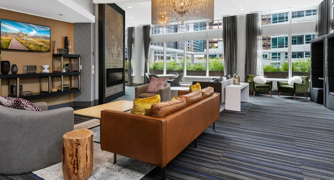 Expansive clubhouse lounge at Atwater Apartments in Chicago, featuring stylish furniture, a large TV, and elegant lighting fixtures