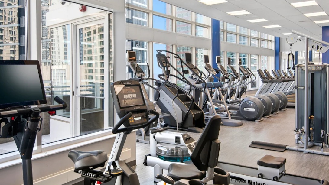 State-of-the-art fitness center at Atwater Apartments in Chicago, featuring a variety of cardio machines and expansive city views