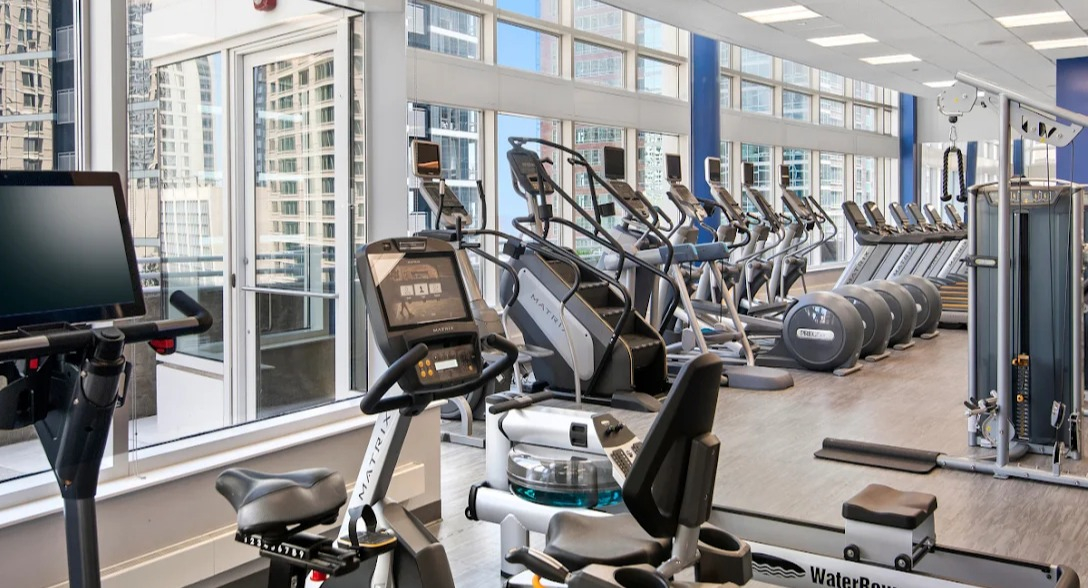 State-of-the-art fitness center at Atwater Apartments in Chicago, featuring a variety of cardio machines and expansive city views