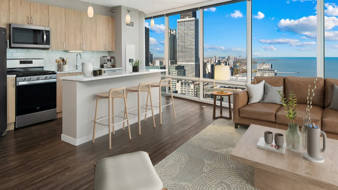Open-concept kitchen and living room at Atwater Apartments in Chicago, featuring modern appliances, a large island, and stunning lake views