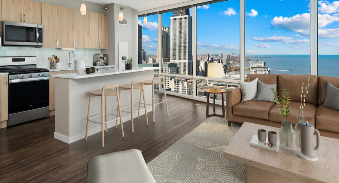 Open-concept kitchen and living room at Atwater Apartments in Chicago, featuring modern appliances, a large island, and stunning lake views
