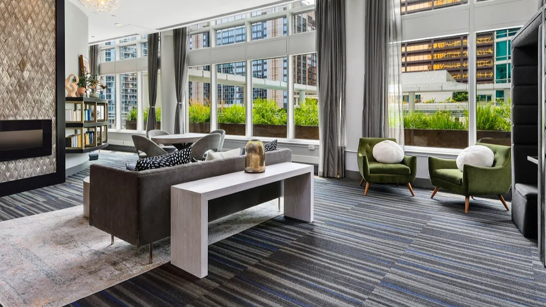Modern resident lounge at Atwater Apartments in Chicago, featuring diverse seating, a fireplace, and private work pods