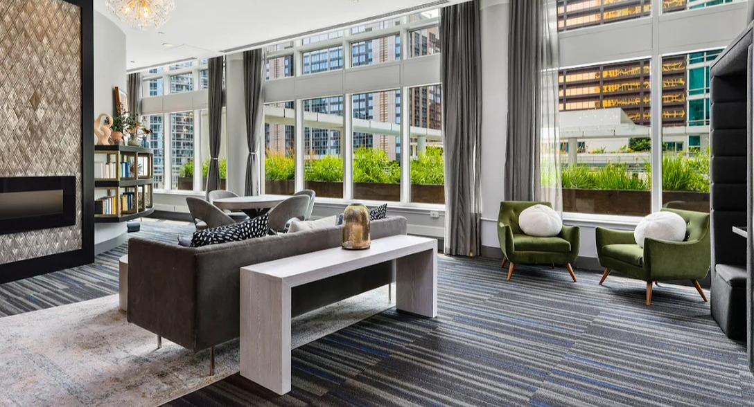 Modern resident lounge at Atwater Apartments in Chicago, featuring diverse seating, a fireplace, and private work pods