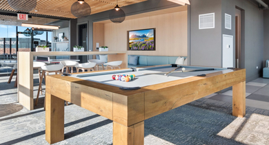 Fun-filled game room featuring a billiards table, comfortable seating, and large windows at Avenir apartments in Chicago