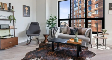 An eclectic living room with a cowhide rug, a comfortable sofa, and unique shelving at Avenir apartments in Chicago