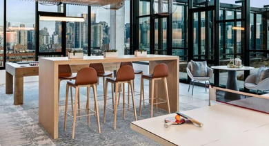 Engaging resident game lounge with ping pong, a high-top table, and stunning city views at Avenir apartments in Chicago