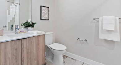Modern bathroom with a wood-finish vanity, large mirror, and clean design at Avra West Loop in Chicago