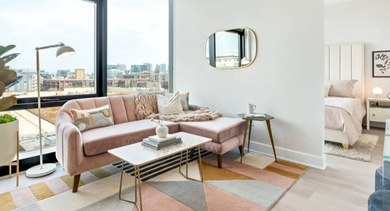 A cozy living area and adjacent bedroom with large windows at Avra West Loop apartments in Chicago