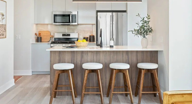Contemporary kitchen island with bar seating and modern appliances at Avra West Loop in Chicago