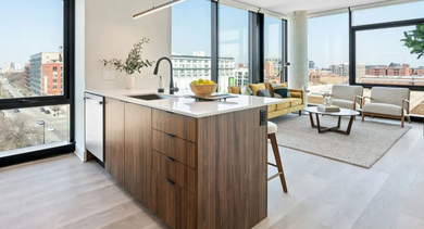Bright, open-concept kitchen and living area with city views at Avra West Loop apartments in Chicago