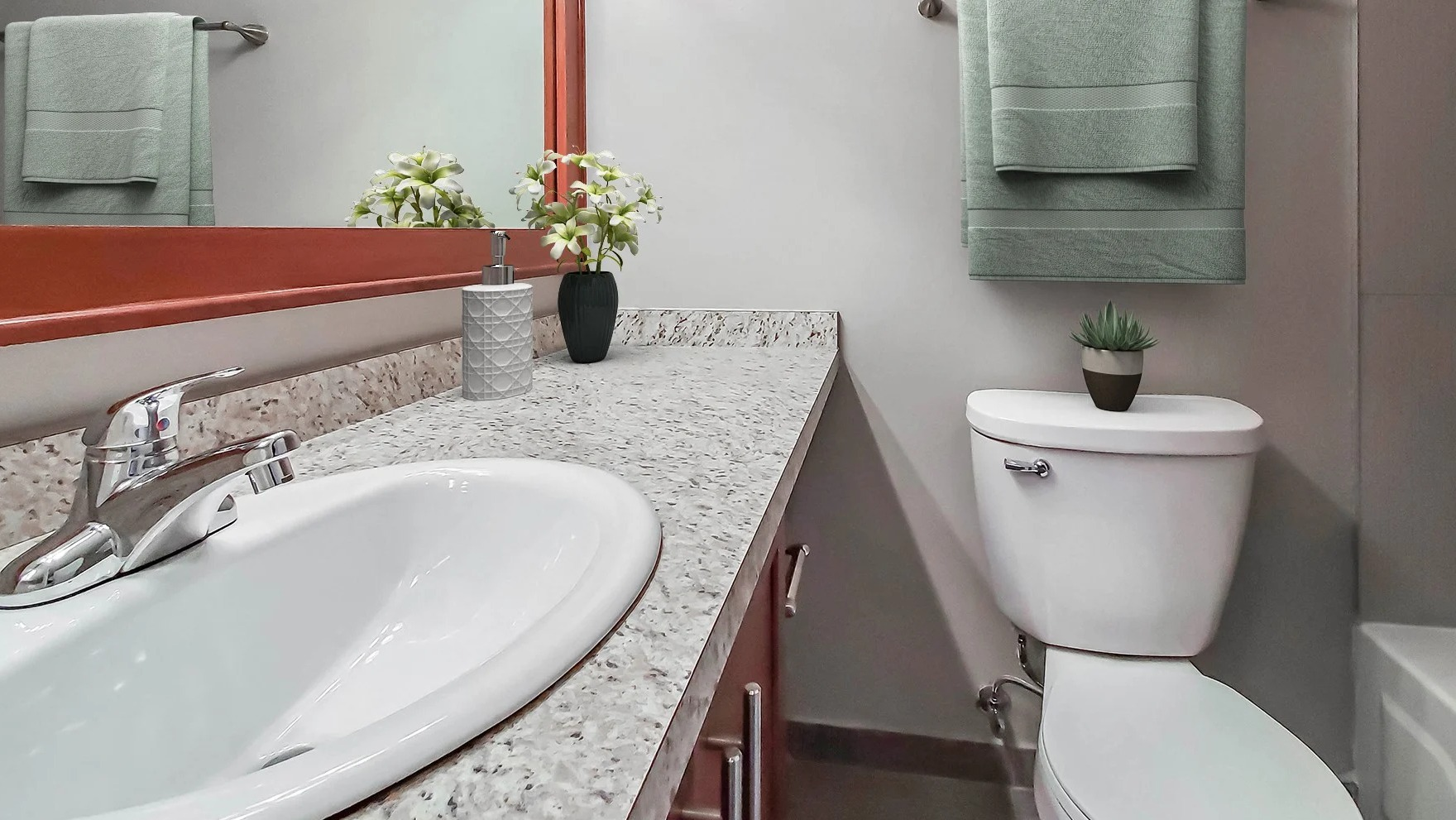 Contemporary bathroom with a granite vanity and a spacious mirror at Axis Apartments & Lofts in Chicago